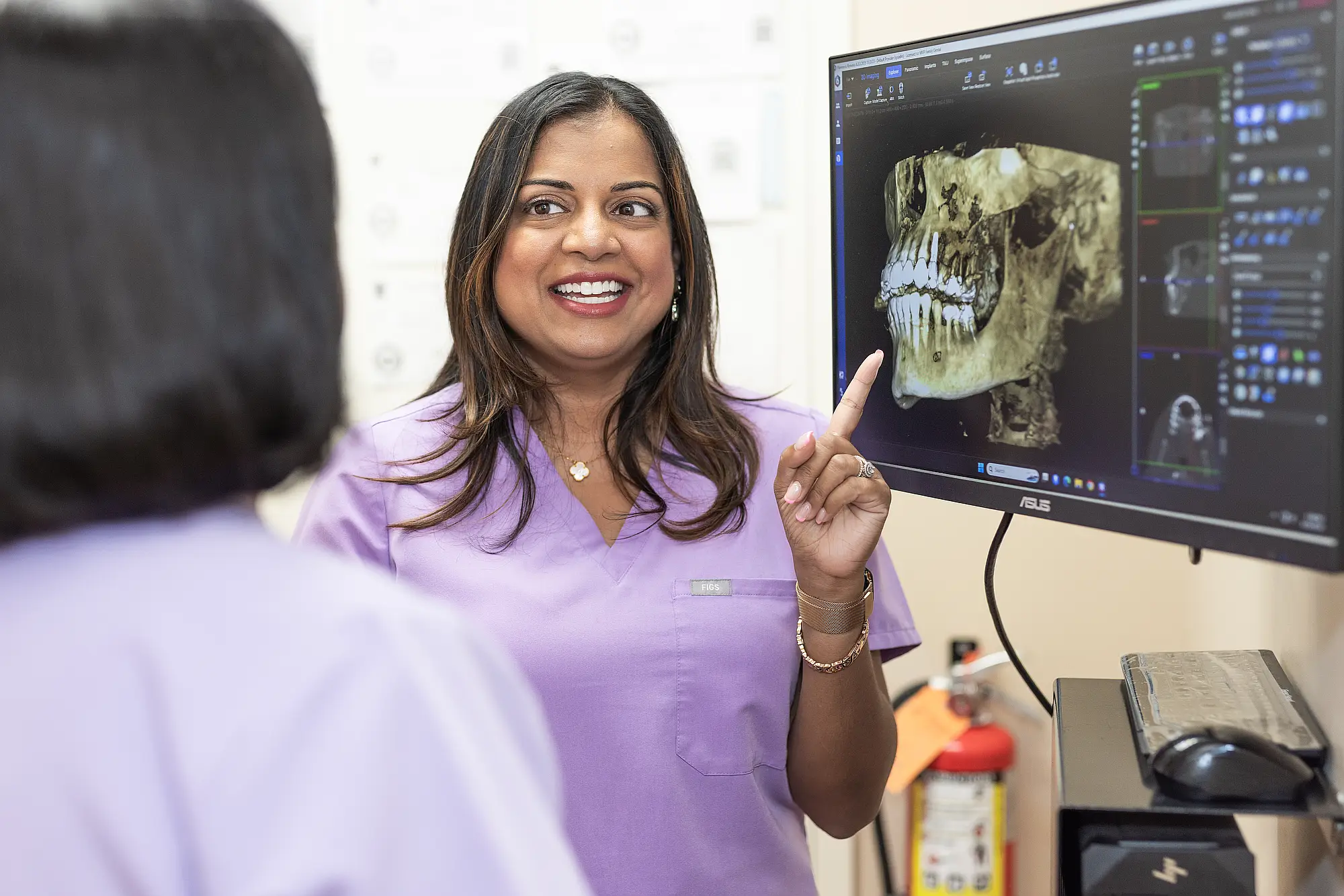 Dr. Priya Mathew pointing at a 3D scan of a patient's jaw