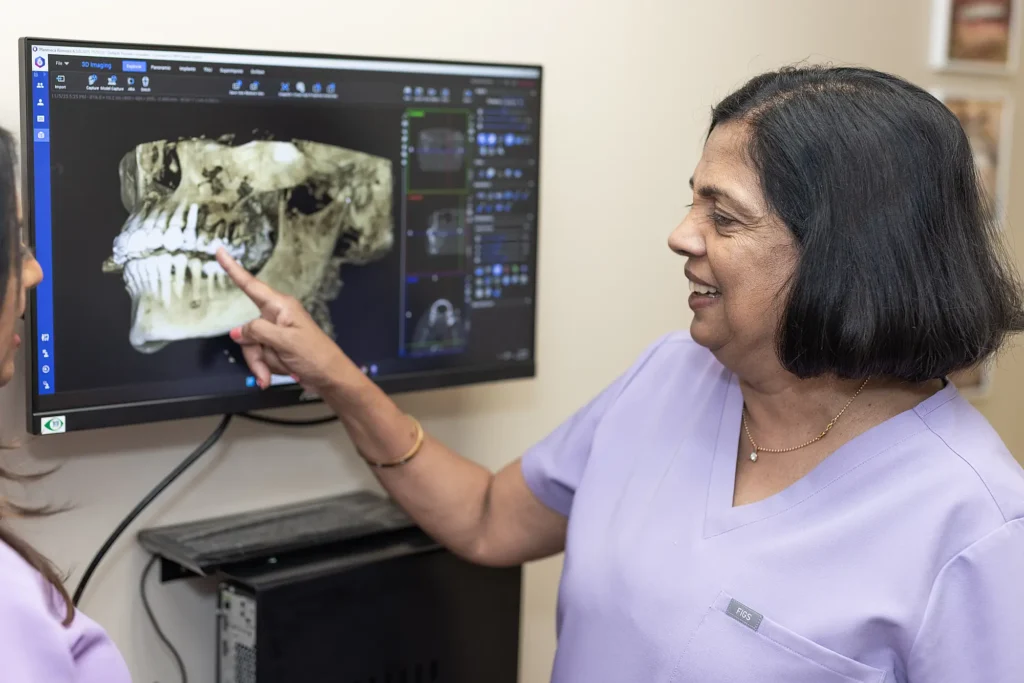 Dr. Vineetha Thomas pointing at a 3D jaw scan on a monitor