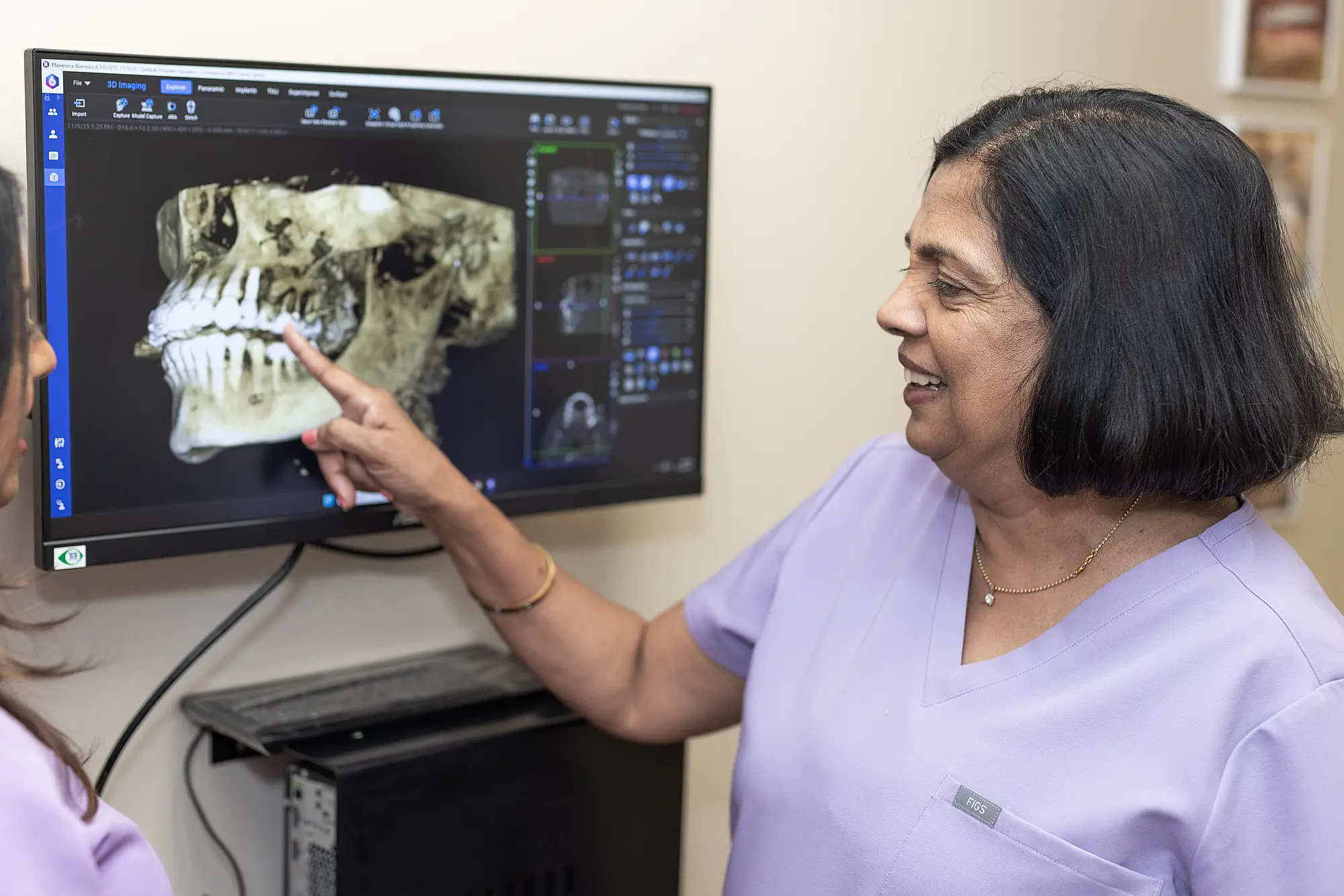 Dr. Vineetha Thomas pointing at a 3D jaw scan on a monitor