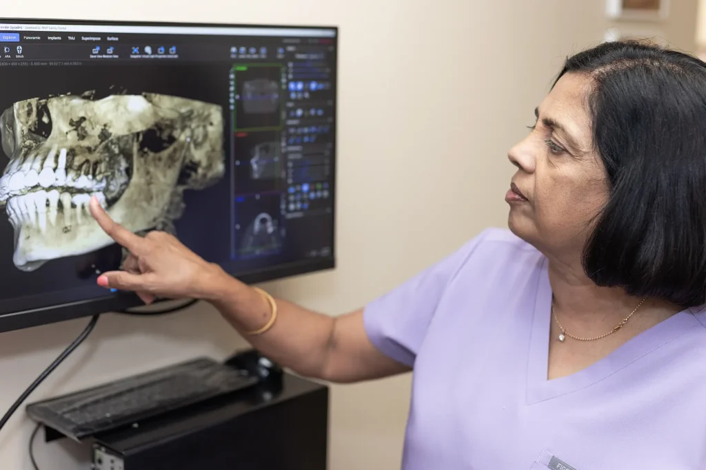 Dr. Vineetha Thomas reviewing a 3D scan of a patient's jaw