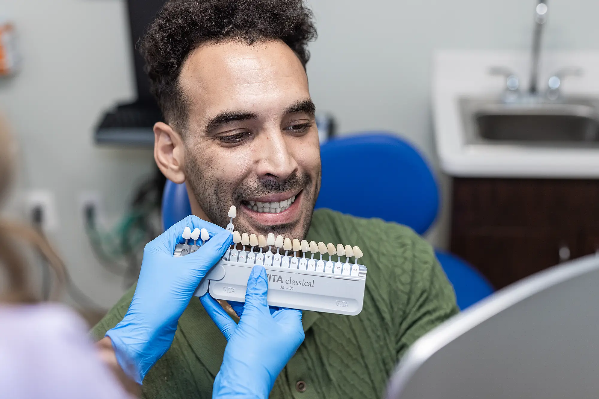 Patient having his tooth shade matched with a shade guide