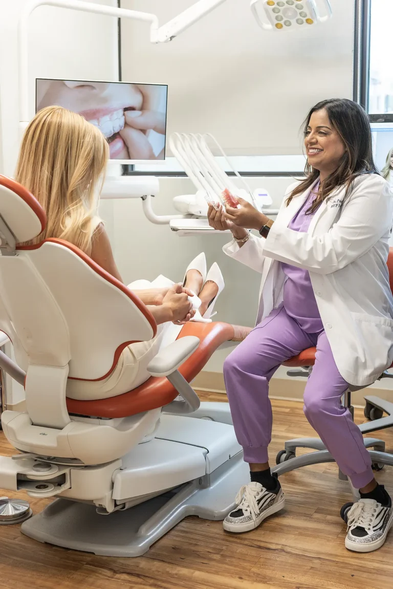 Dr. Priya Mathew seated beside a patient in a treatment room