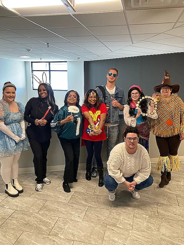 The whole team in Halloween costumes gathered in the office