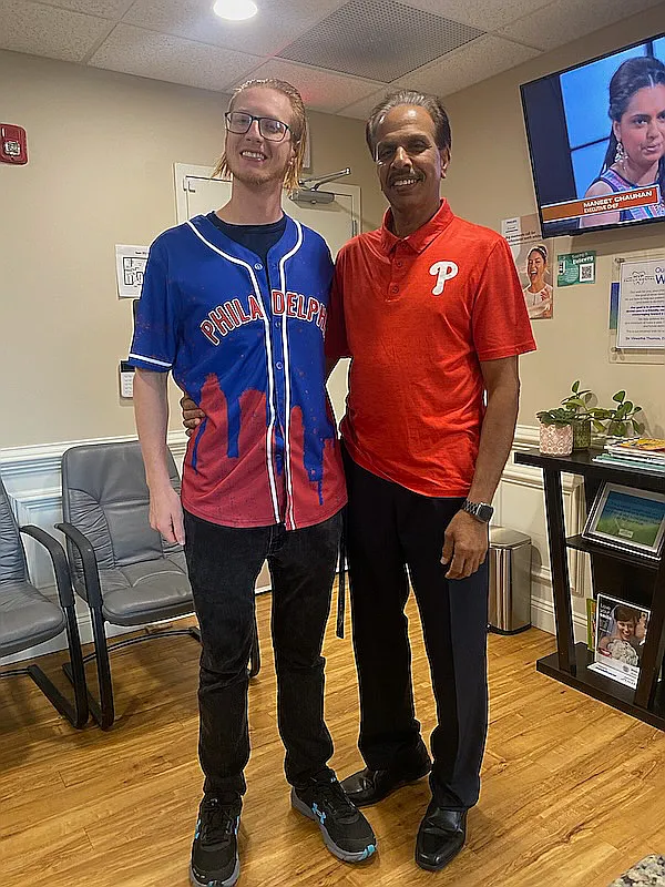 Two men in Phillies shirts standing in the waiting room